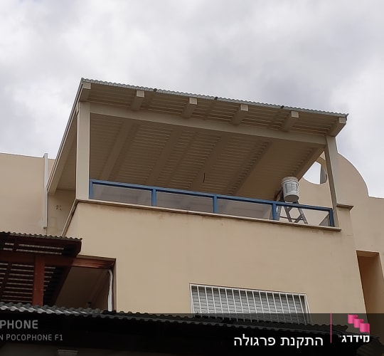 מרפסת עם גג עץ ומעקה זכוכית כחול